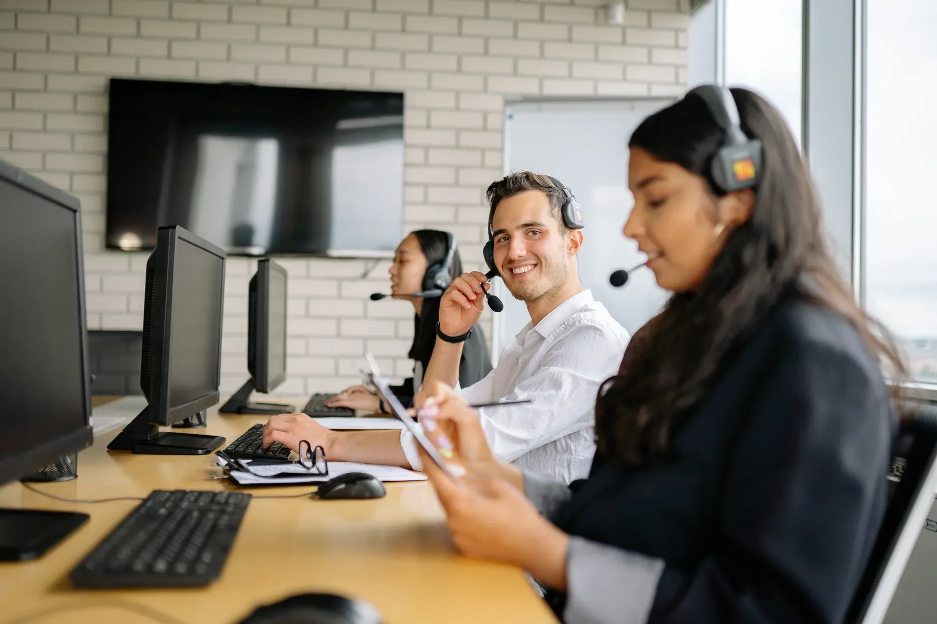 Equipe de atendimento registrando conversas do WhatsApp em um CRM no computador