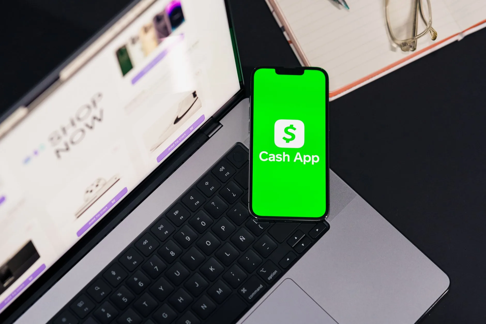 Celular exibindo uma confirmação de pagamento Pix ao lado de um caderno com pedidos de uma loja online