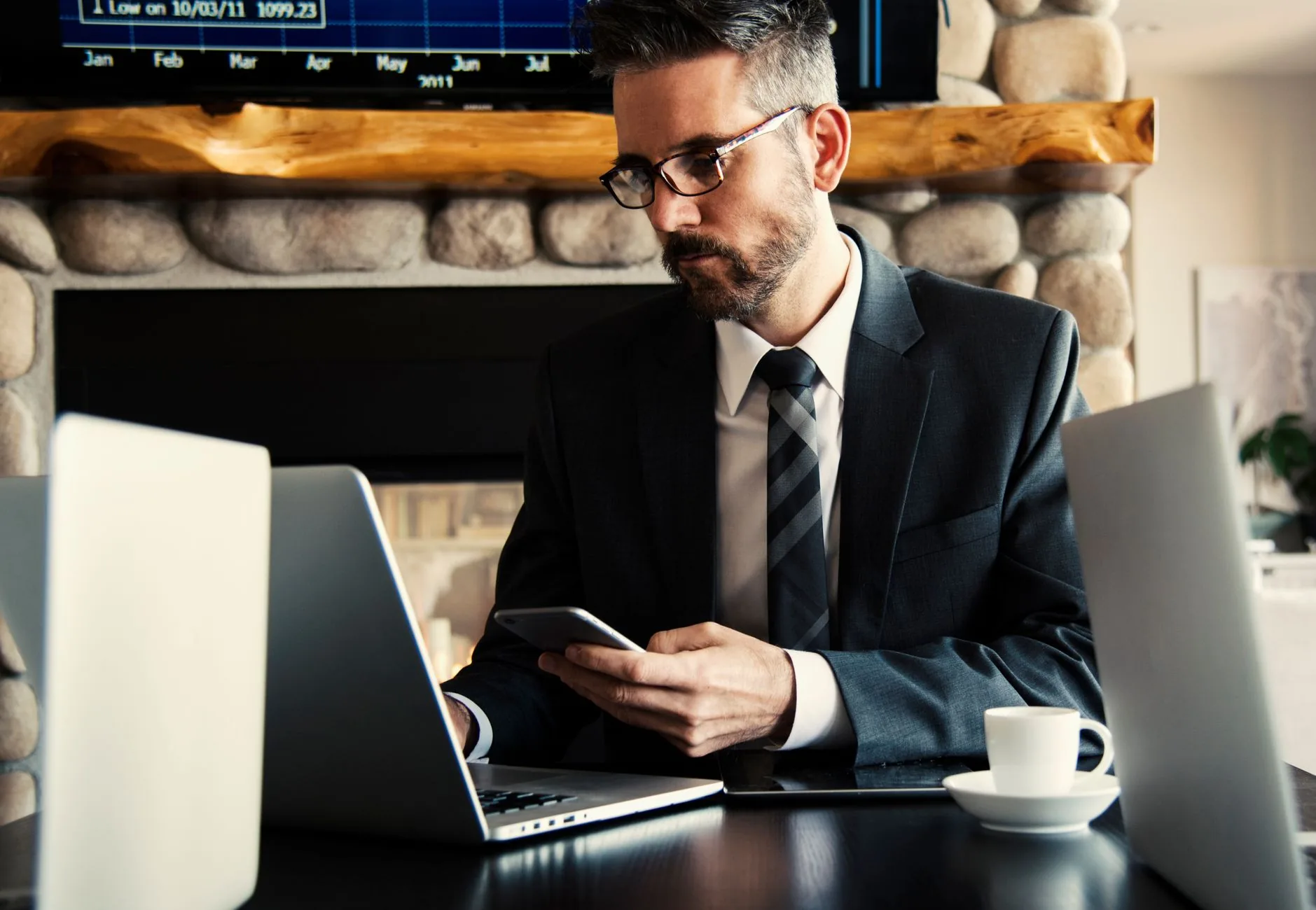 Profissional registrando conversa do WhatsApp no HubSpot no notebook enquanto atende pelo celular